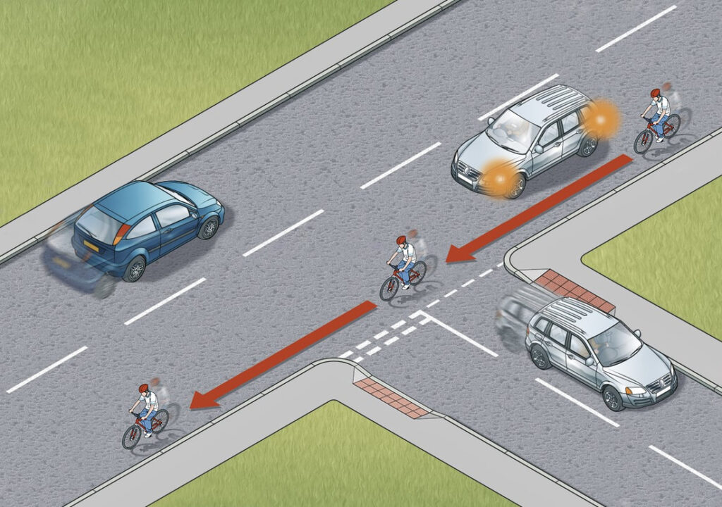 Wait for the cyclist to pass the junction before turning